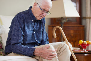 Senior man sitting down with knee pain