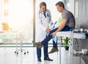 A yound man seeing an orthopedic specialist for his knee pain.