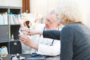 Hip Surgeon presenting total hip arthroplasty to female patient