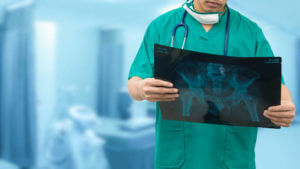 Surgical doctor examining xray film, diagnose patient 's waist bone. Surgery operation concept.