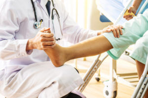 Doctor examining of the leg from the knee and ankle and training broken leg patient in hospital