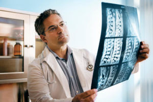 Spine Surgeon Examines The Patients Spine X-ray