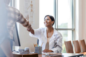 Female bone doctor shaking patient's hand